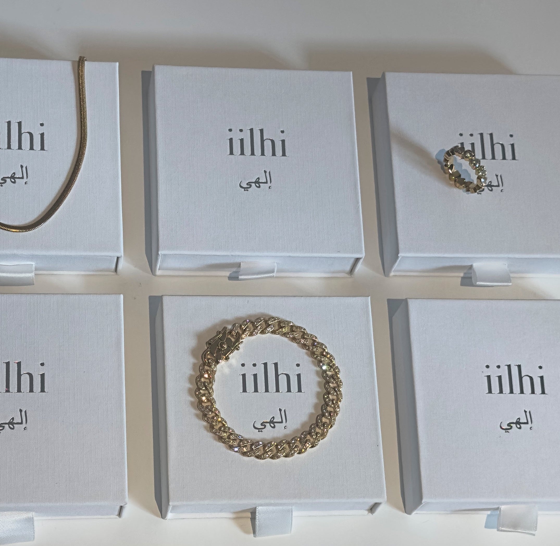 Jewelry display with 'iilhi' branding on white boxes.