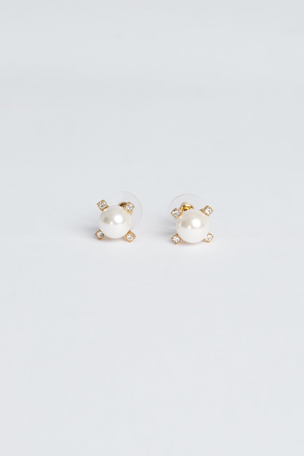 Pair of pearl stud earrings on a light gray background