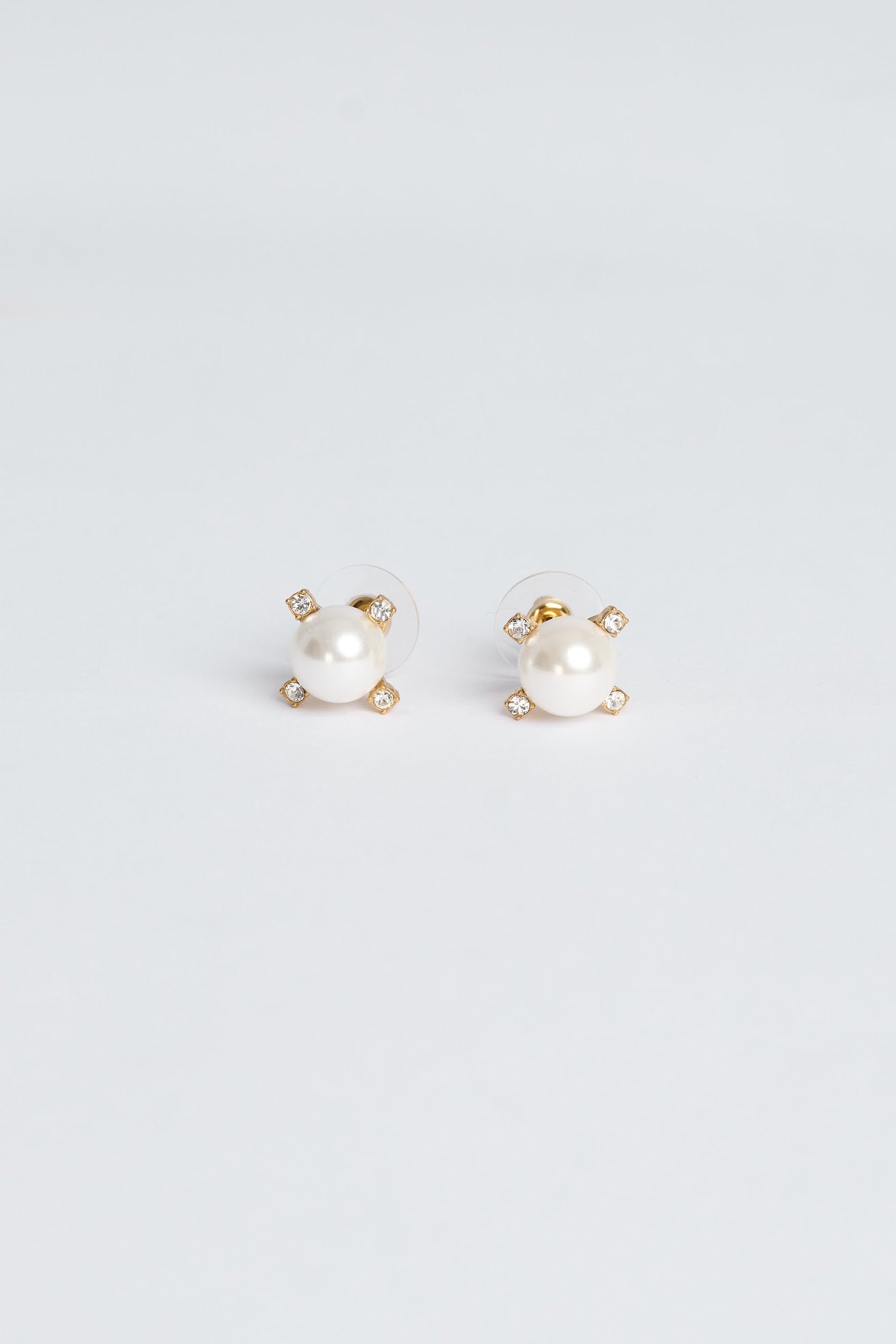 Pair of pearl stud earrings on a light gray background
