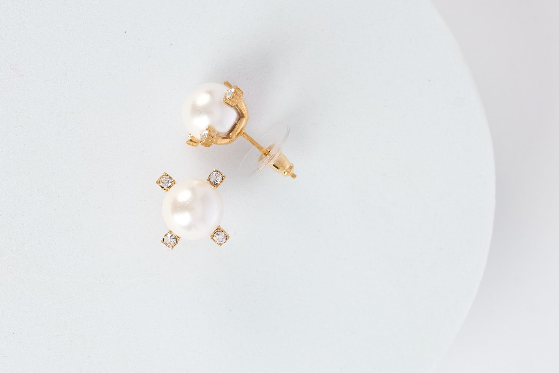 Gold and pearl earring on a white background