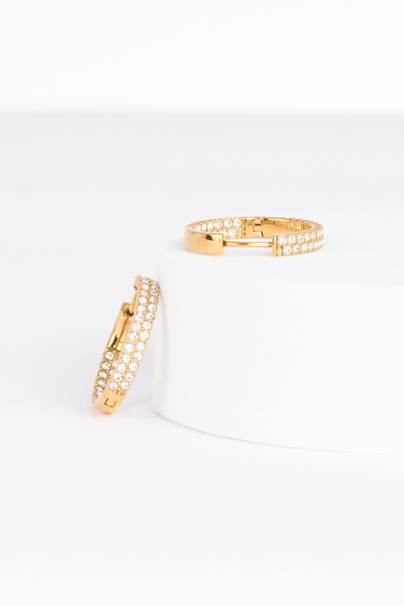 Two gold earrings on a white background