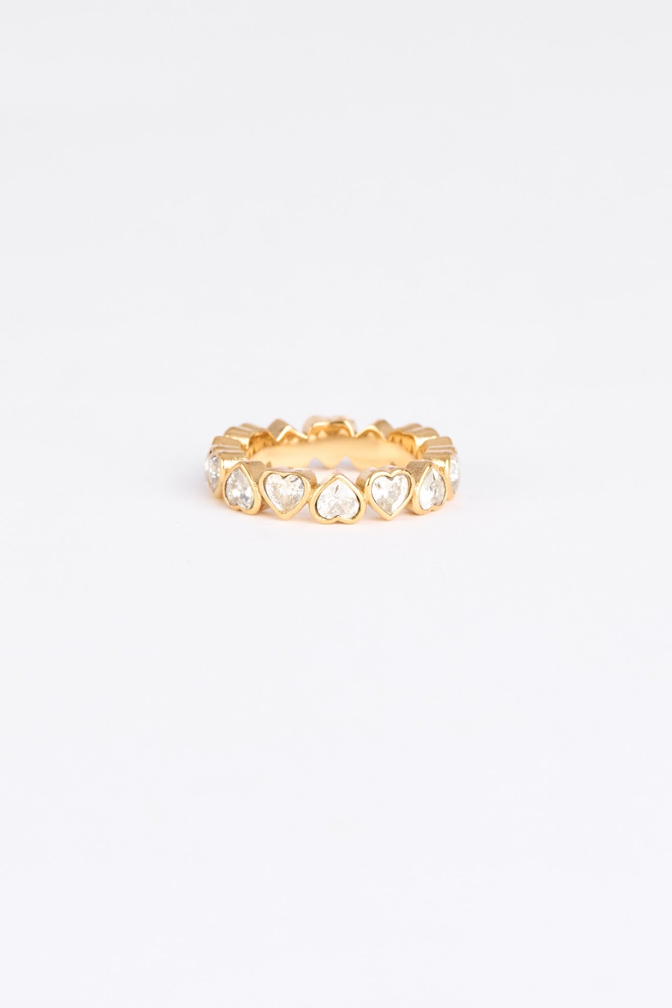 Gold ring with clear gemstones on a light gray background