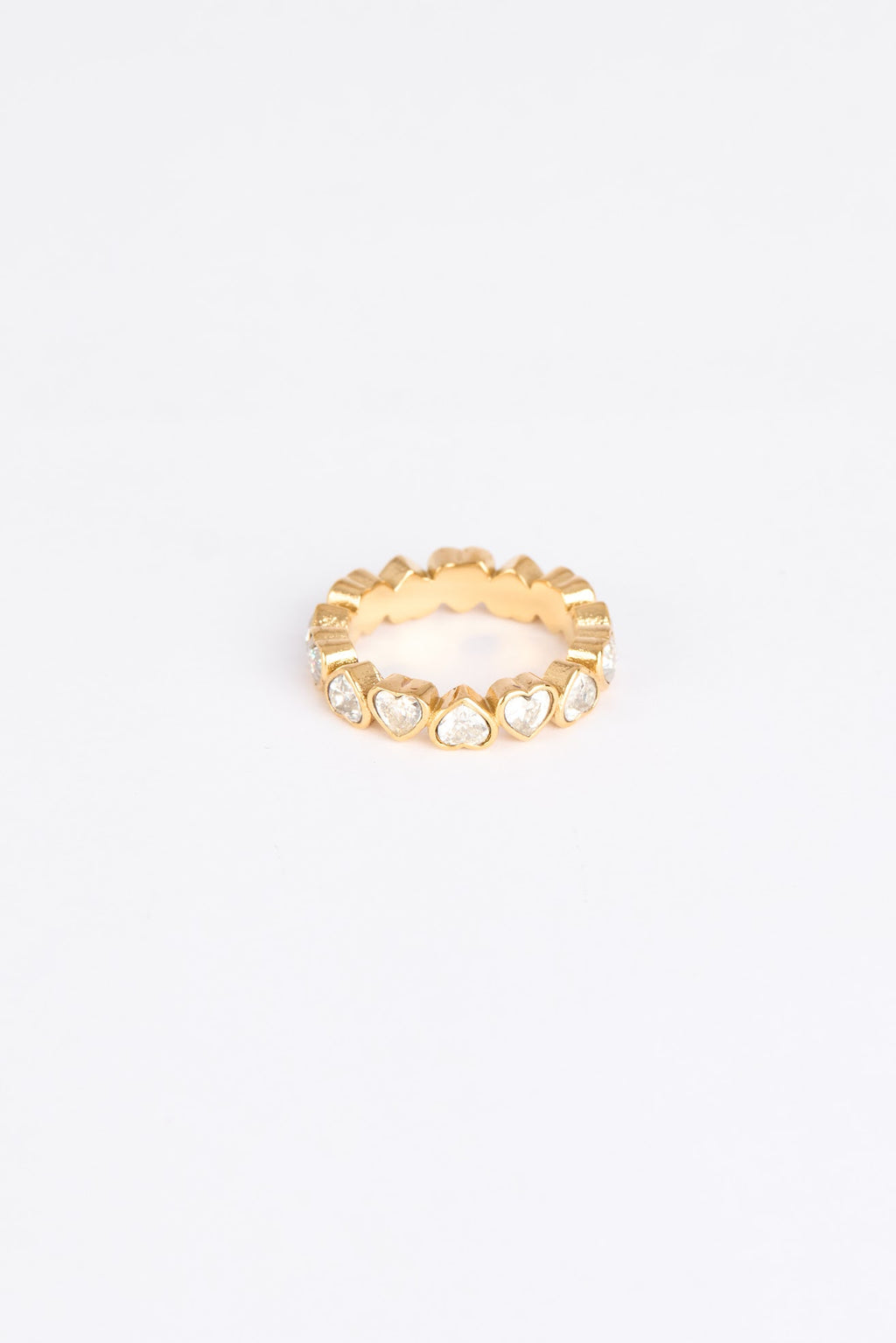 Gold ring with heart-shaped stones on a white background