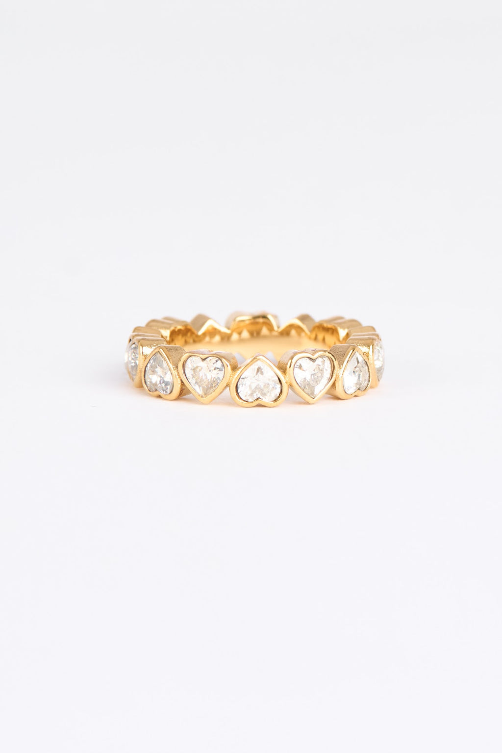 Gold ring with heart-shaped gemstones on a white background