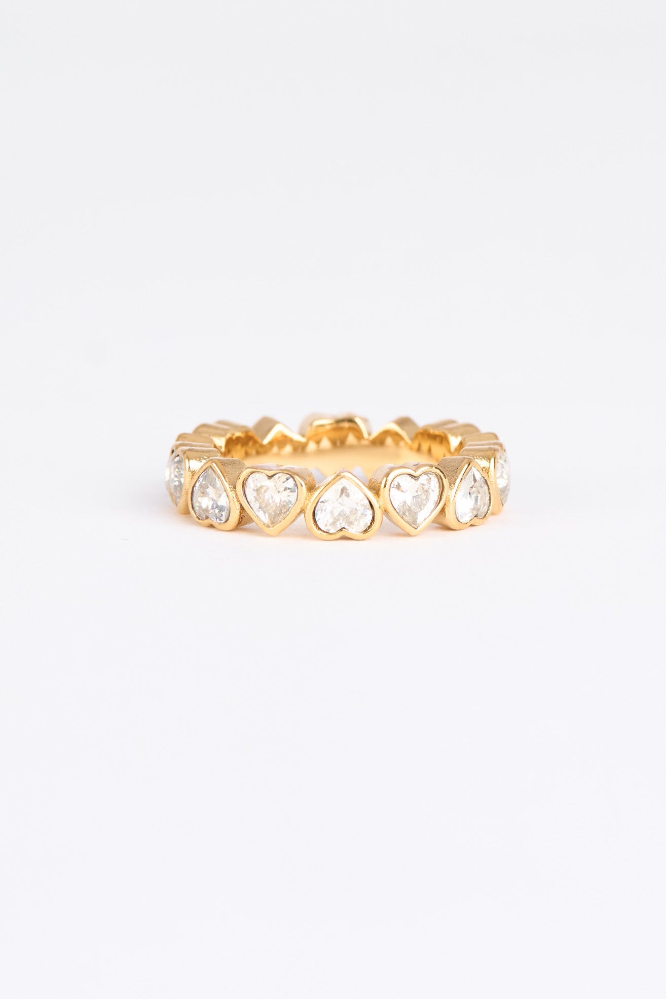 Gold ring with heart-shaped gemstones on a white background