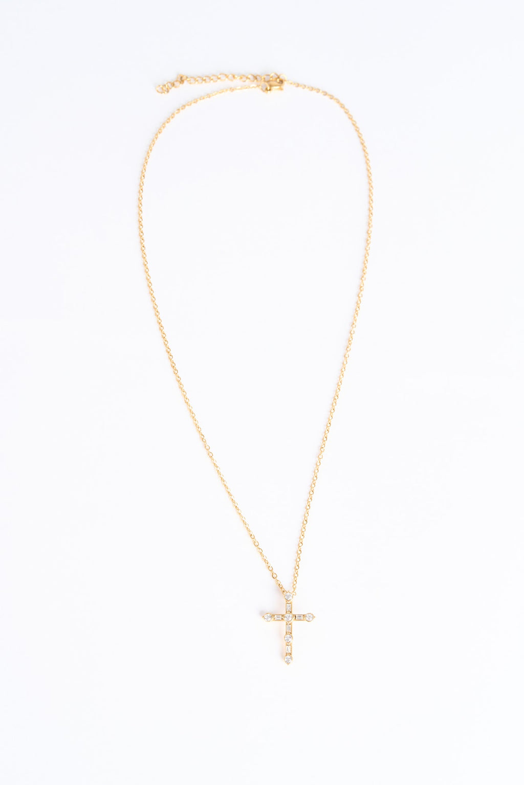 Gold necklace with a cross pendant on a white background