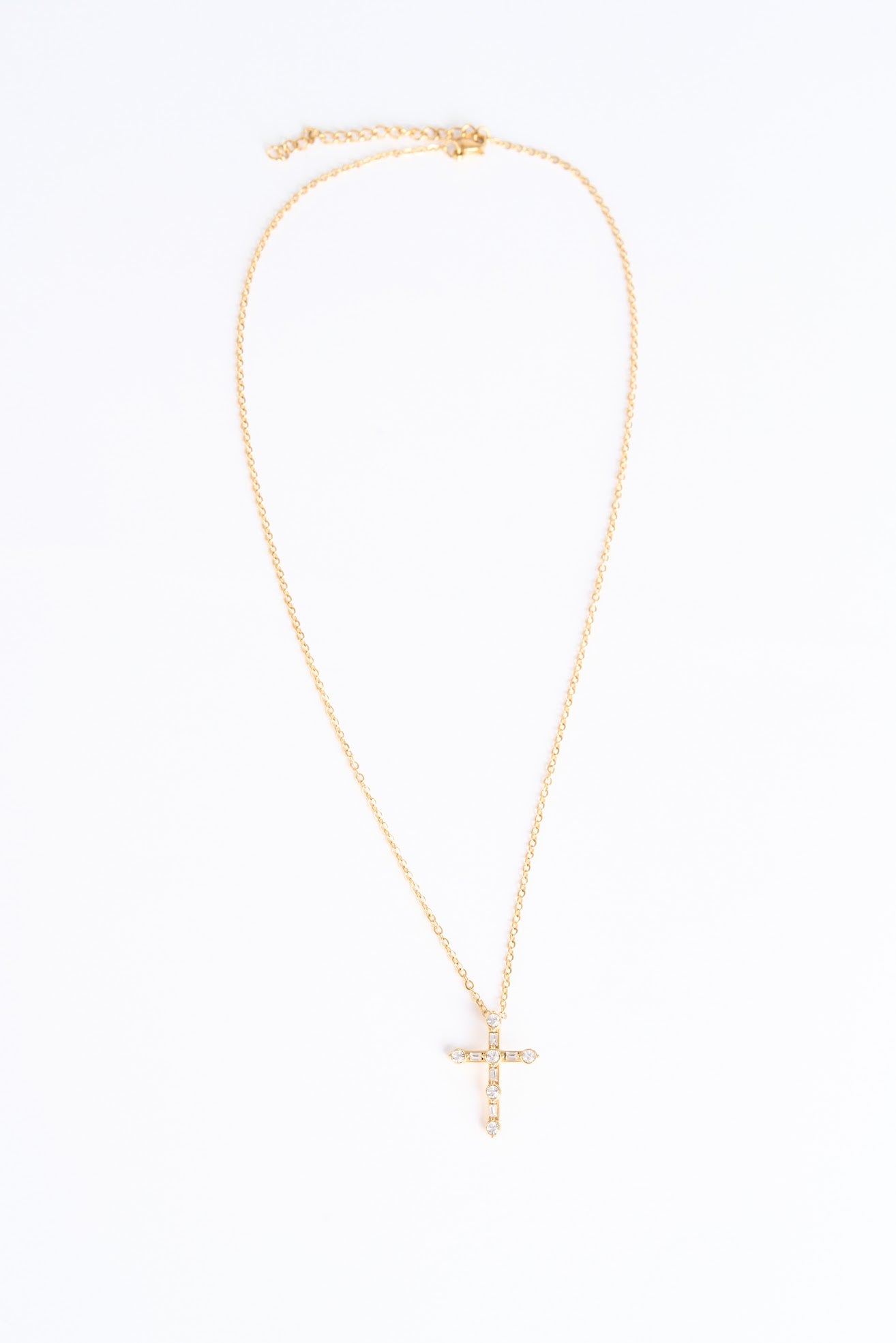 Gold necklace with a cross pendant on a white background
