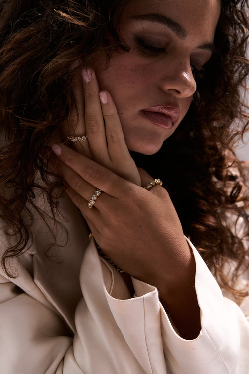 Woman wearing gold jewelry with a neutral background