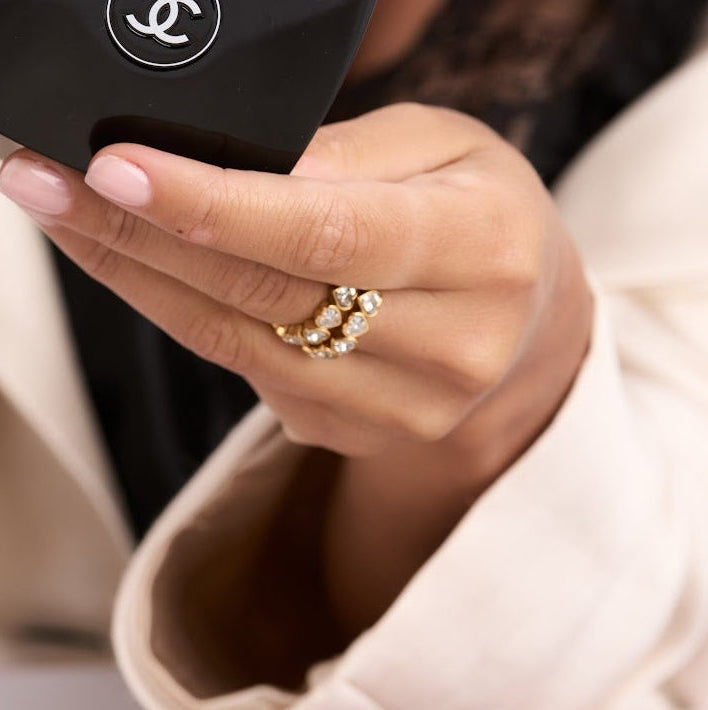 Person holding a Chanel makeup compact with a magazine in the background