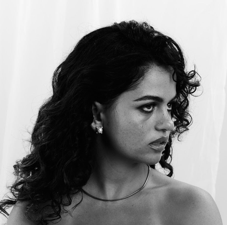 Black and white photo of a woman holding a Vogue magazine